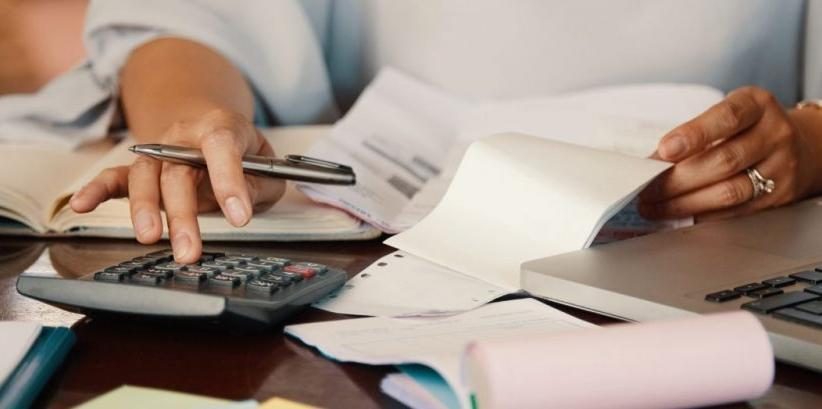Persona revisando cifras con una calculadora